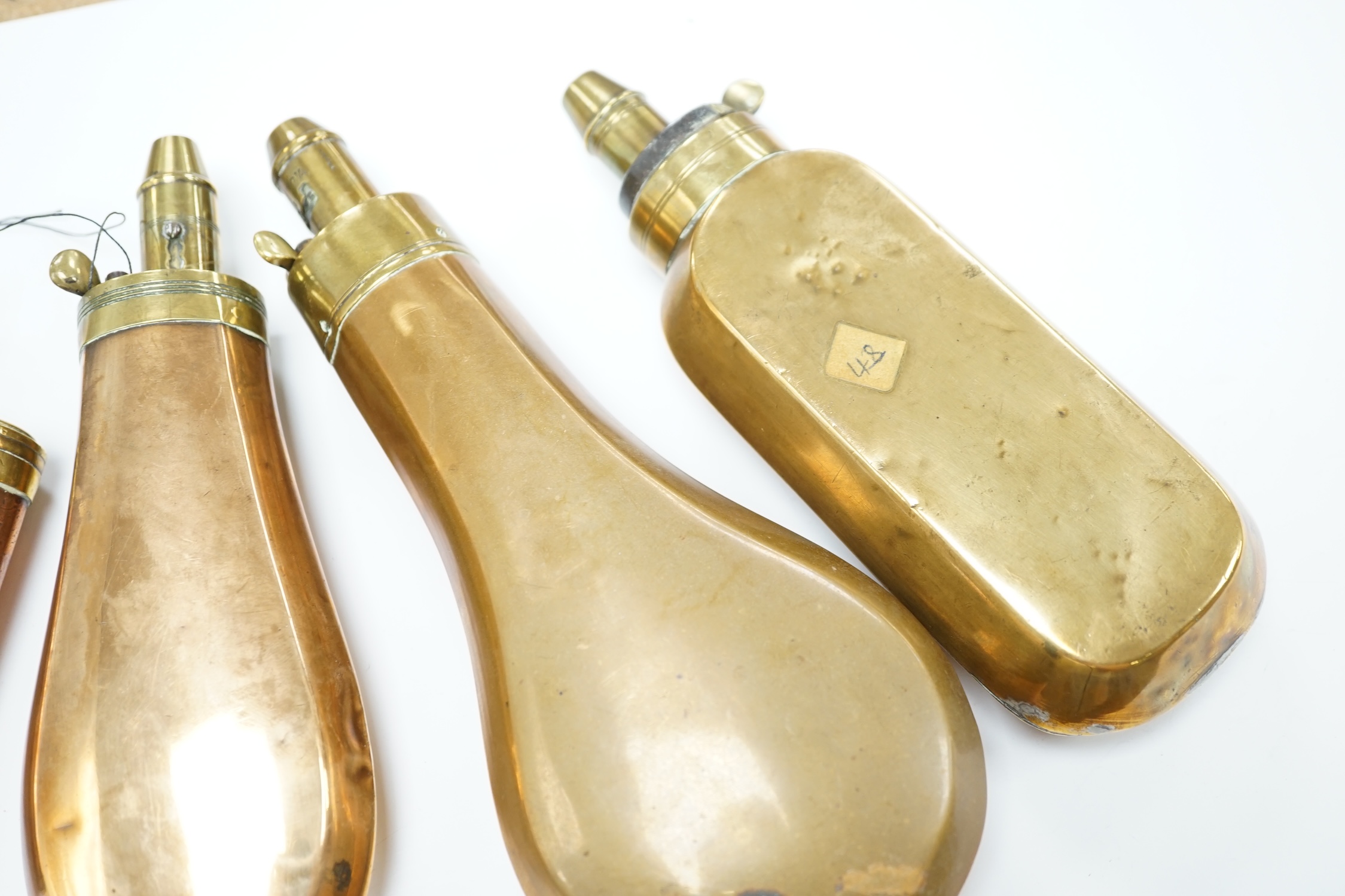 Five 19th century copper and brass powder flasks, all with plain copper bodies. Condition - fair
